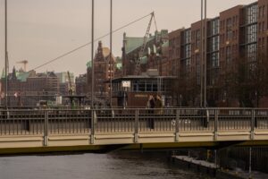 Enjoy a scenic view of Hamburg's historic architecture with people strolling across a bridge.