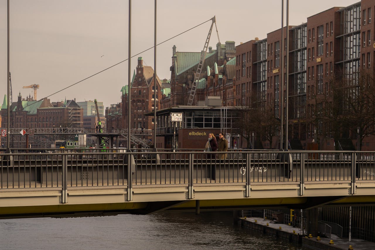 Enjoy a scenic view of Hamburg's historic architecture with people strolling across a bridge.